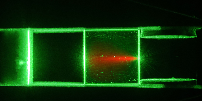 Photo: Jonas Neergaard-Nielsen and Sepehr Ahmadi. A diamond illuminated with green laser light flouresces red light.